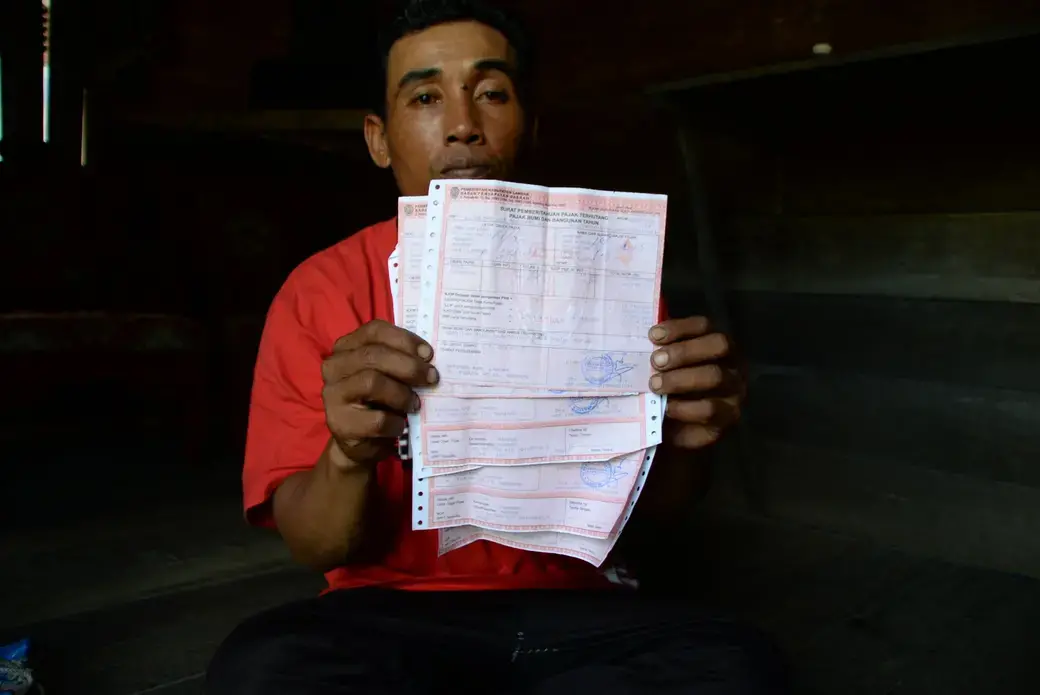 Abdul Hadi, Ketua RT Dusun Kopiang memperlihatkan Surat Pemberitahuan Pajak Terhutang (SPPT) Pajak Bumi dan Bangunan (PBB).